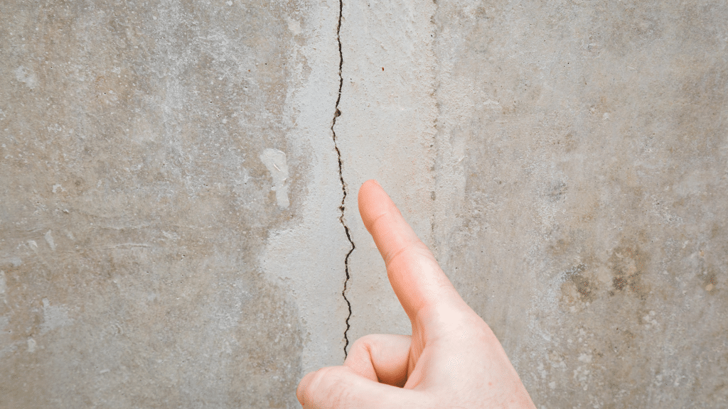 finger pointing at a vertical wall crack