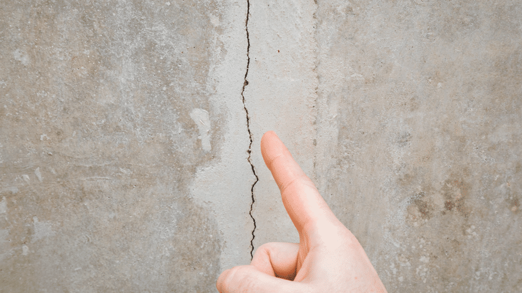 finger pointing at a vertical wall crack