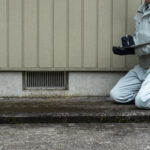 Person in protective gear completing a mold inspection on a home.